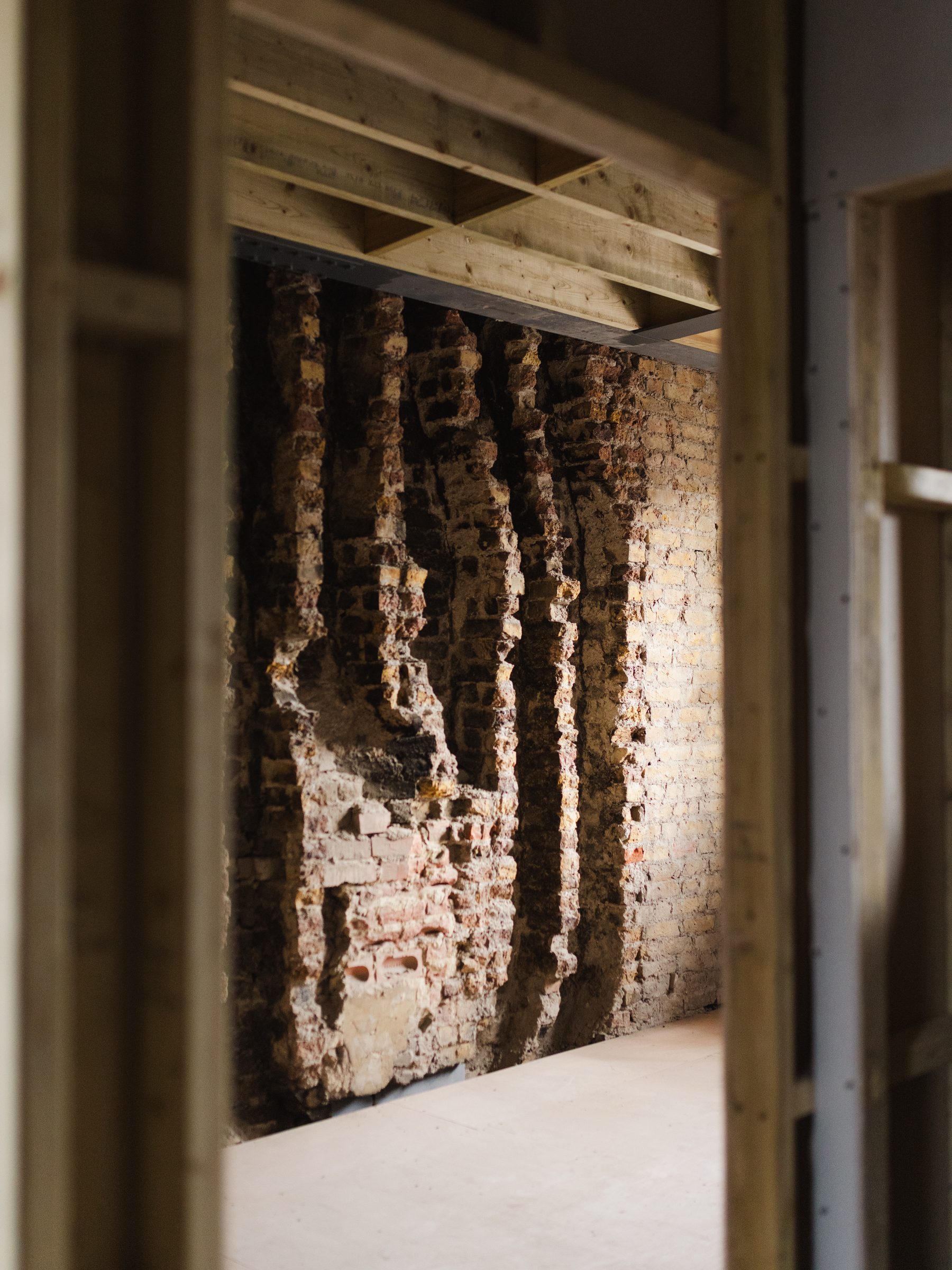 Exposed brickwork framed by new timber studs
